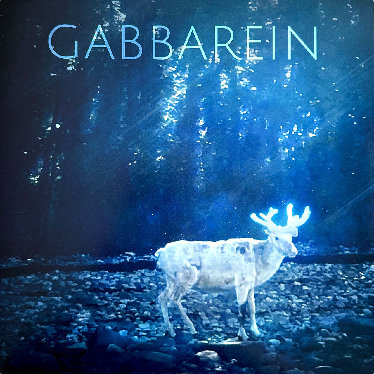 Gabbarein album cover — a glowing white reindeer on a rocky riverbed in a blue-lit northern forest